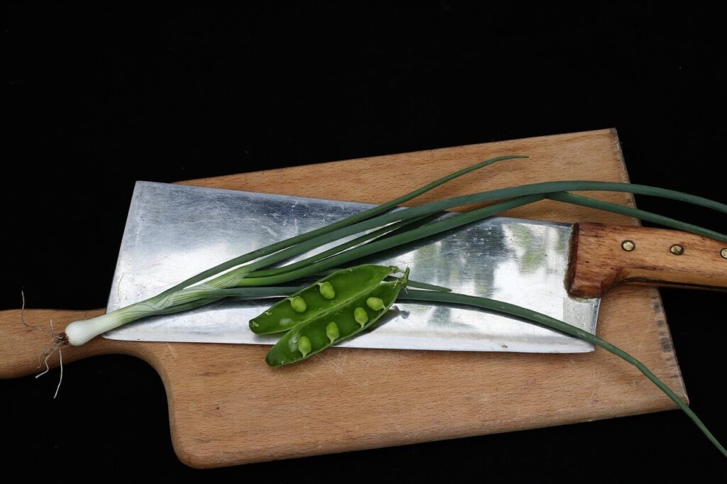cleaver on wooden cutting board with herbs