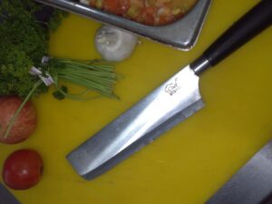 nakiri knife on yellow cutting board